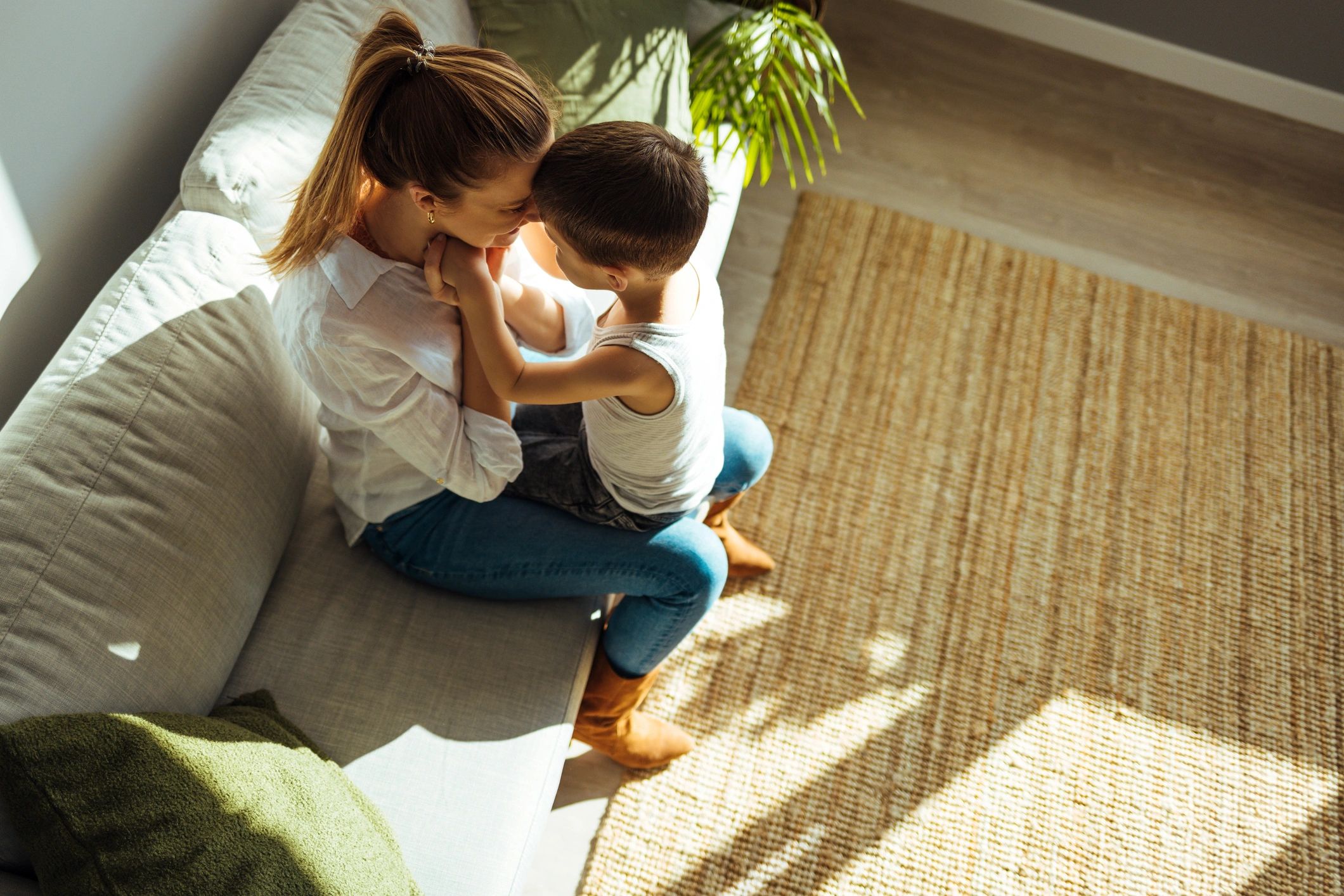 Happy family playing together on couch indoors