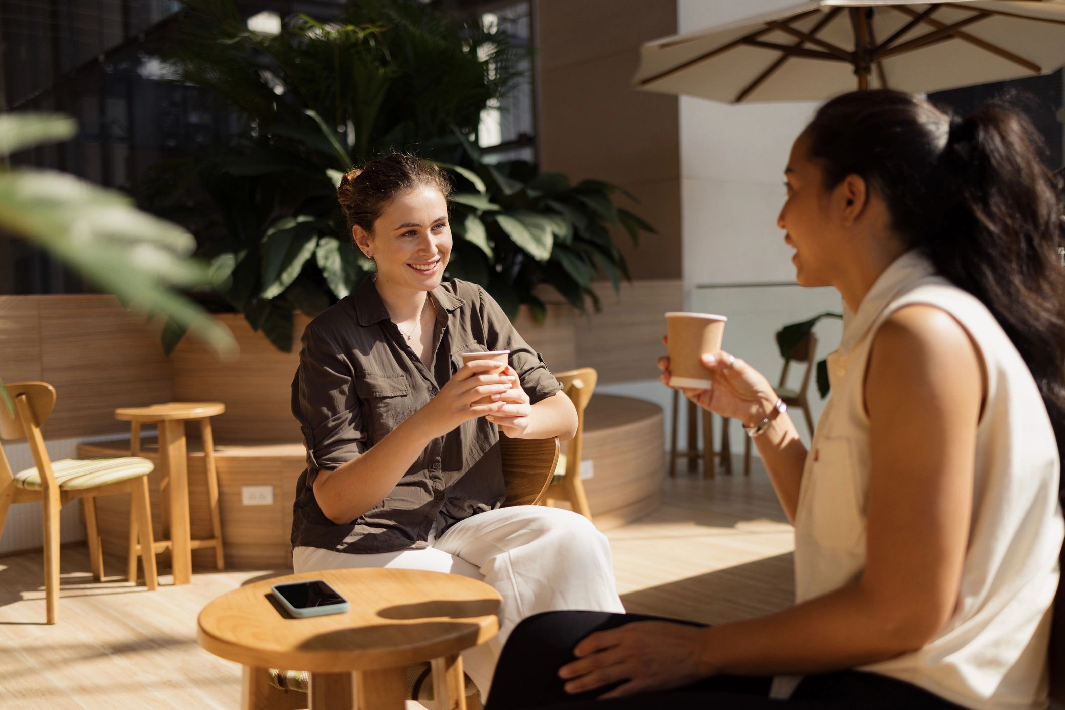 Happy women talking in coffee shop.